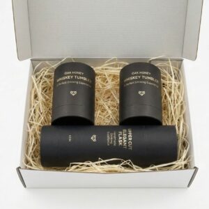 Handcrafted Oak Honey Whiskey Tumblers and Upper Cut Flask on a dark wooden home bar.